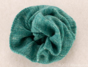 Gentle on Hair, Strong in Hold: Wrap your hair in the softness of cashmere without compromising on strength.  California Craftsmanship: Ethically made in California, our scrunchies feature sustainable cashmere from Mongolian goat herders.  Hand-Dyed Yarn: Choose from a variety of hand-dyed colors, making it a stylish and personalized gift, this one is green with white specks